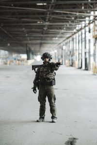 Police officer holding an AR15 in a warehouse